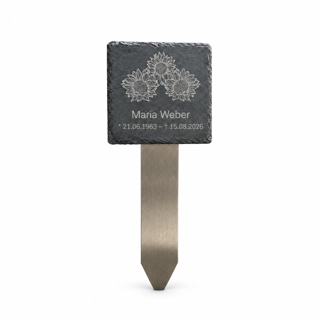 Personalisierter Grabstecker mit Schiefertafel, Sonnenblumenmotiv, Name und Lebensdaten auf Edelstahl-Erdspieß vor weißem Hintergrund.