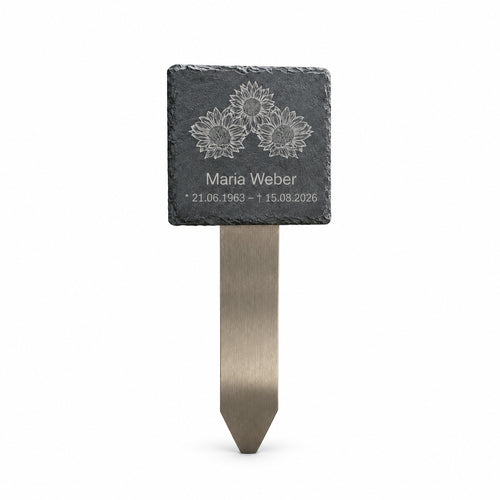 Personalisierter Grabstecker mit Schiefertafel, Sonnenblumenmotiv, Name und Lebensdaten auf Edelstahl-Erdspieß vor weißem Hintergrund.