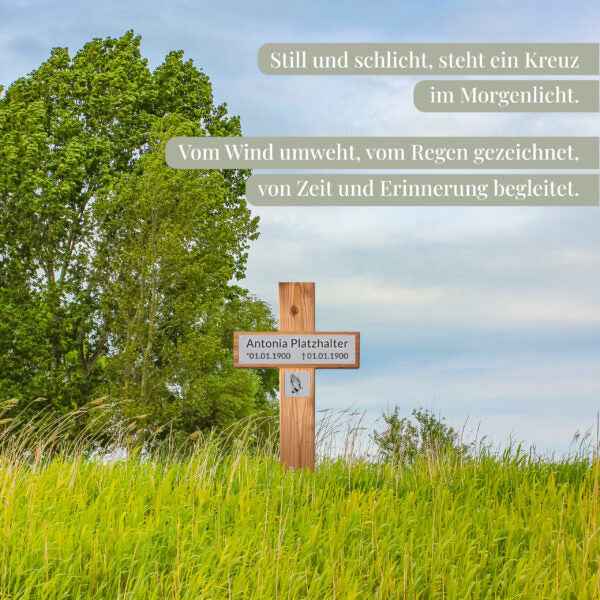 Personalisiertes Holzgrabkreuz mit Namensschild in grüner Wiesenlandschaft