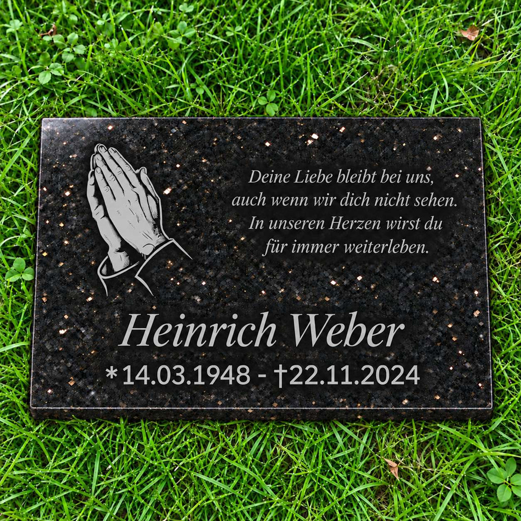 Schwarze Granit-Gedenktafel Star Galaxy mit hellgrauen betenden Händen sowie Name, Datum und Gedicht in Hellgrau auf grünem Rasen.