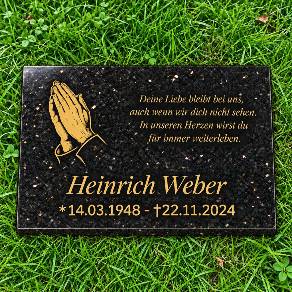Schwarze Granit-Gedenktafel Star Galaxy mit goldenen betenden Händen, personalisiertem Namen, Datum und Gedicht auf grünem Rasen.