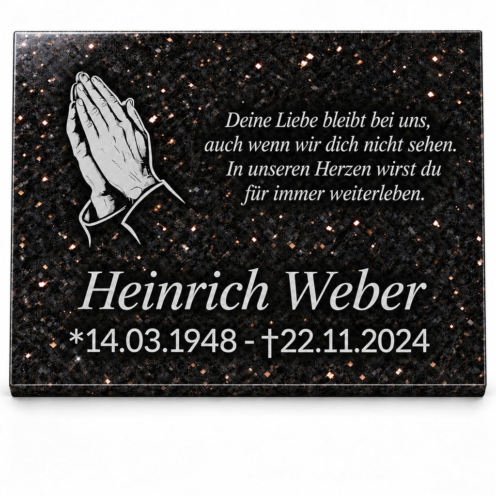 Personalisierte Gedenktafel aus schwarzem Star-Galaxy-Granit mit silbernen betenden Händen, Namen, Lebensdaten und Gedenkspruch auf weißem Hintergrund.
