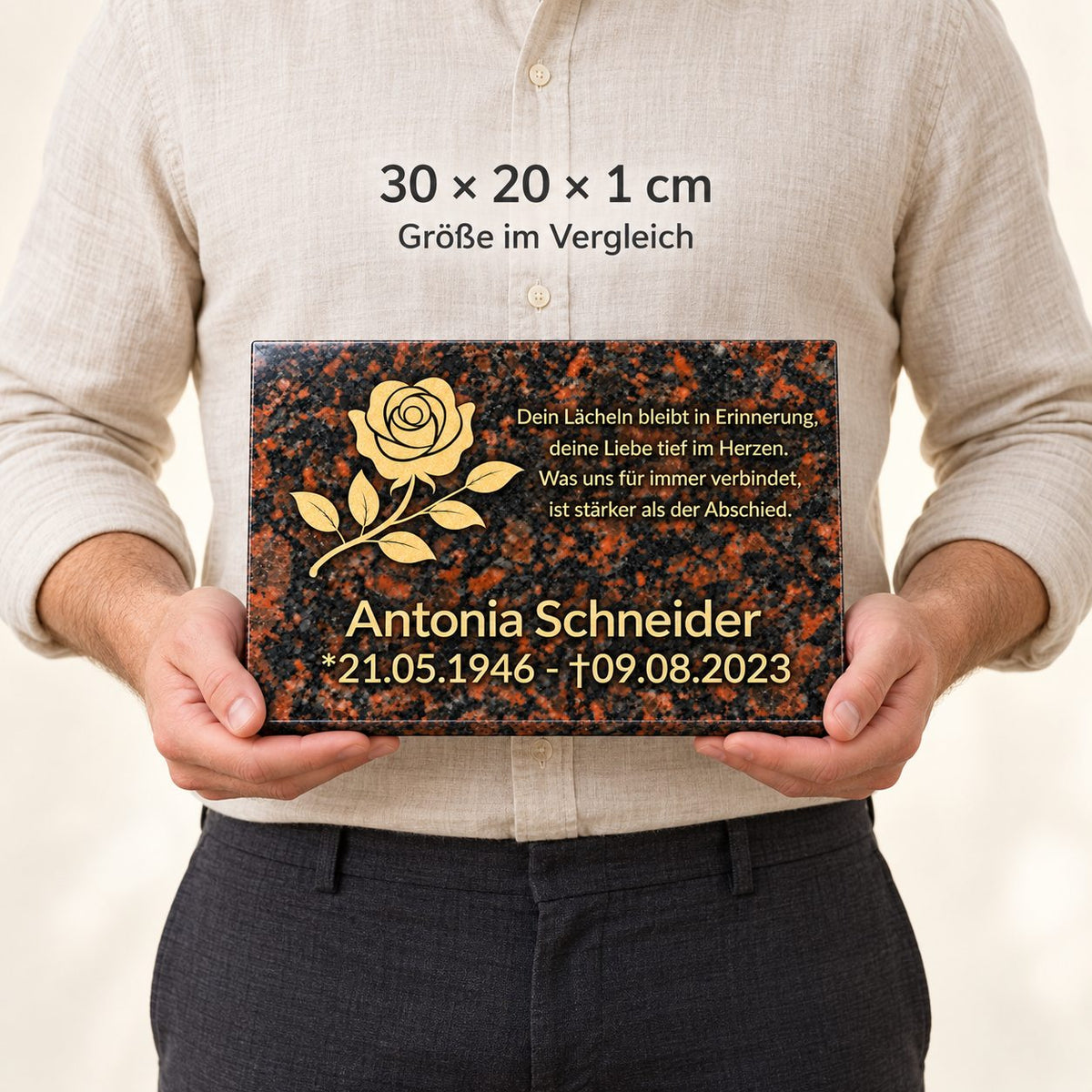 Mann hält eine personalisierte Tan-Brown-Granitgedenktafel mit goldener Rose vor dem Körper zum Größenvergleich, 30 × 20 × 1 cm.